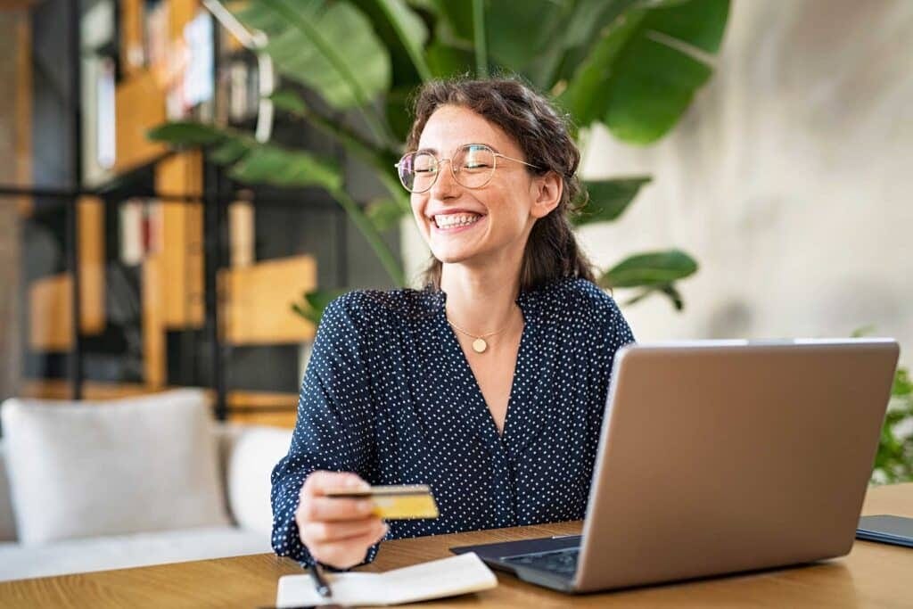 woman with laptop using credit card DZ35VKV